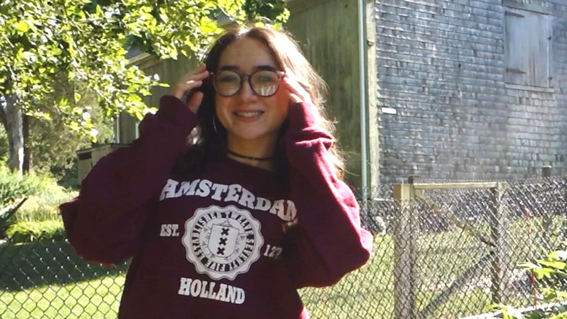 Isabella wearing an Amsterdam sweatshirt to represent her transfer school