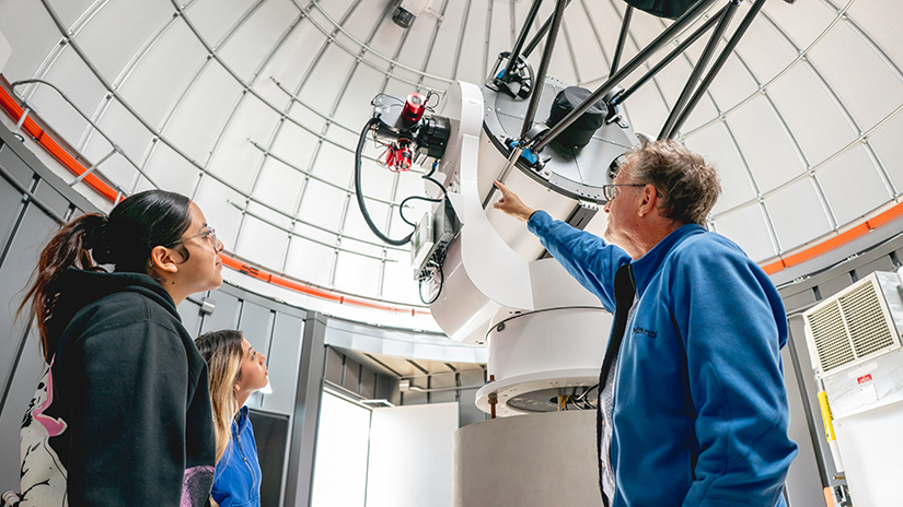 Staff pointing out features of the telescope